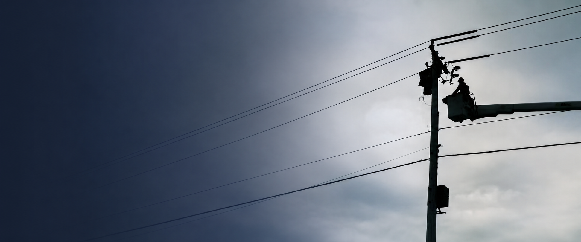 Lineworkers performing overhead utility work from bucket trucks
